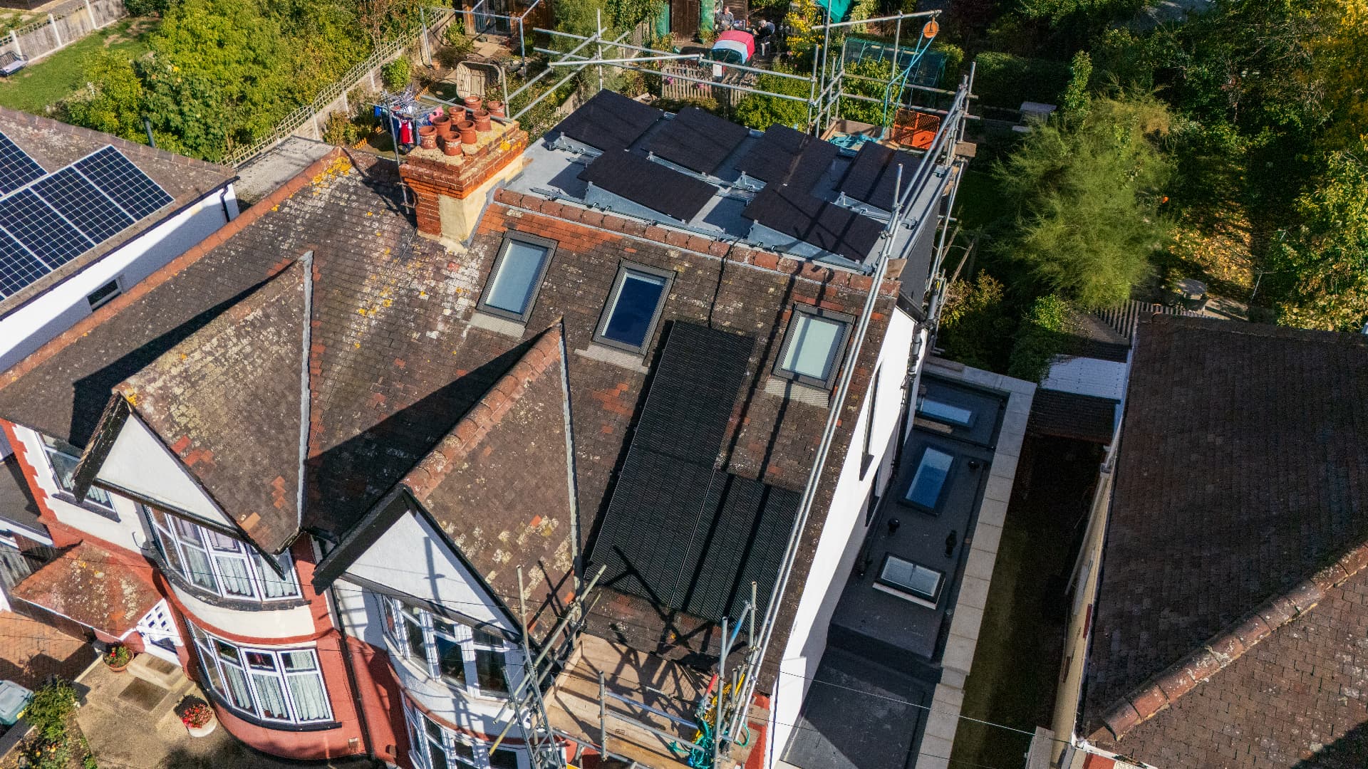 Solar panels being fitted to a home roof with scaffolding in place
